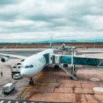 Avião comercial conectado a uma ponte de embarque em um terminal aeroportuário.
